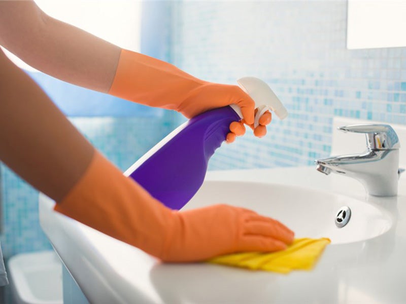 person cleaning wash basin