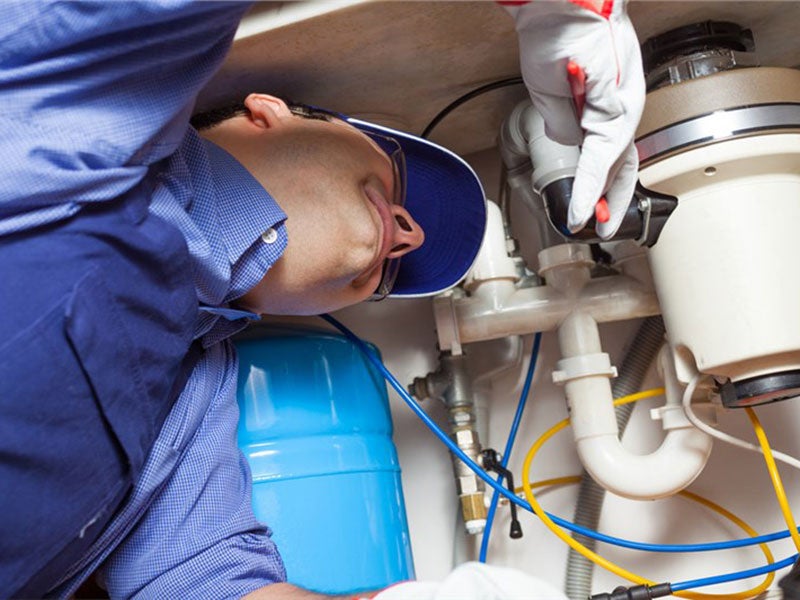 person repairing under the sink