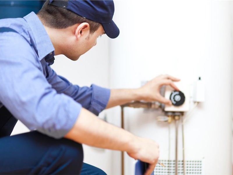 person-adjusting the water heater