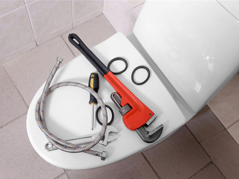 Plumbing tools on a toilet seat