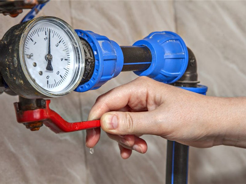 Person using water pressure gauge