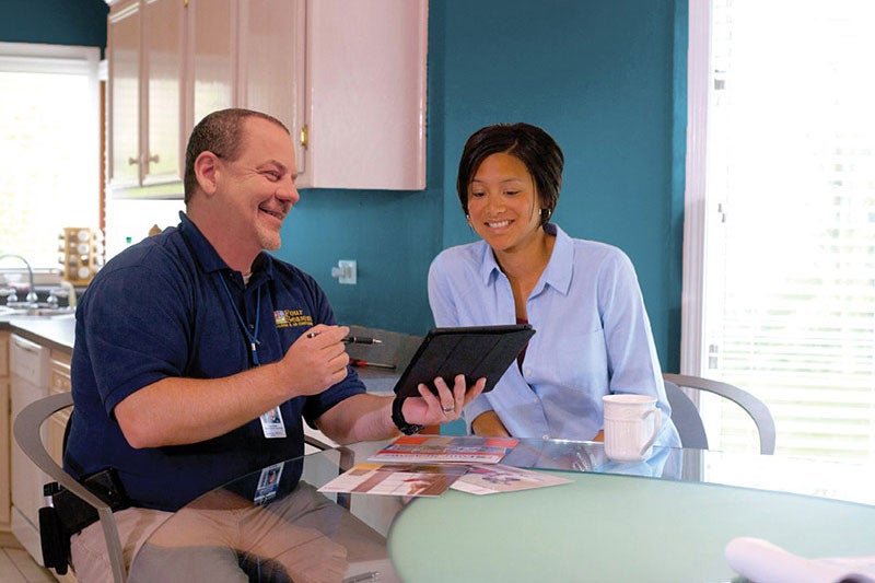 technician showing woman tablet