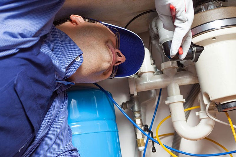 plumber working under kitchen sink