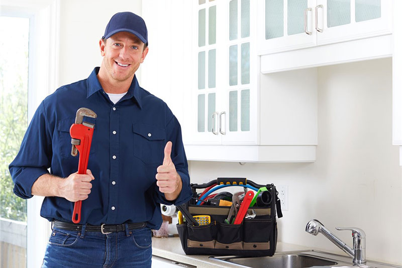 plumber giving thumbs up while holding tools